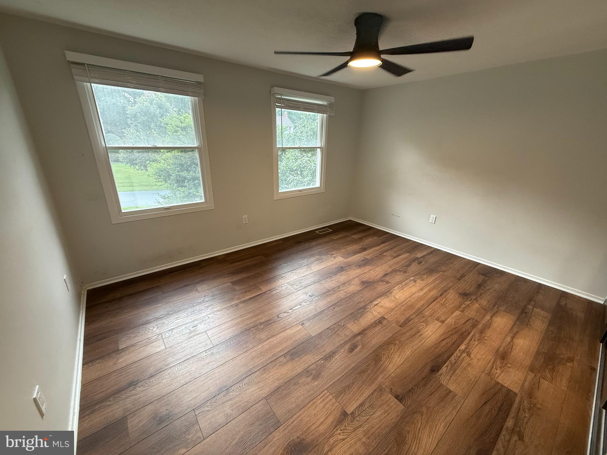 14917 Lear Lane Silver Spring, MD 20905 - Photo 16 of 49 an empty room with wooden floor ceiling fan and windows
