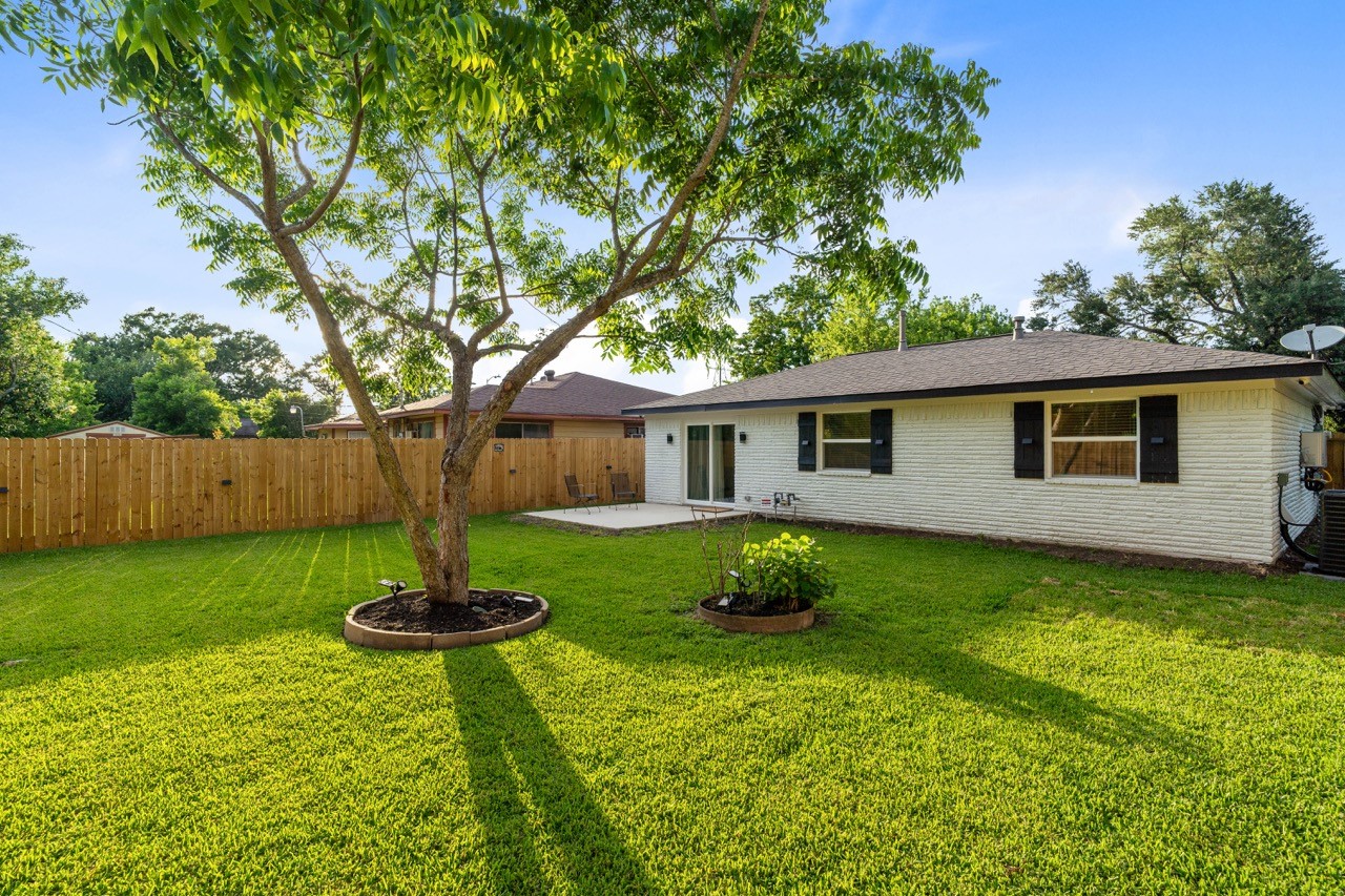 3138 Sunbeam Street Houston, TX 77051 - Photo 43 of 50 Golden hour transforms this oversized backyard into a peaceful sanctuary framed by a mature pecan tree and glowing natural light.