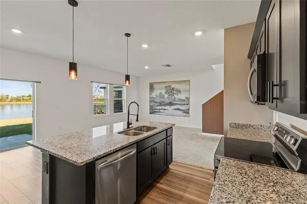 a kitchen with stainless steel appliances granite countertop a sink and a refrigerator