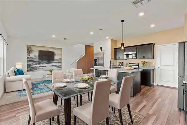a view of a dining room with furniture kitchen and wooden floor