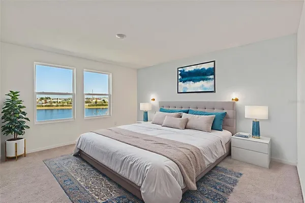 a bedroom with a large bed and a potted plant