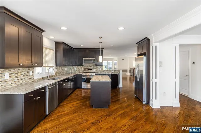 a kitchen with a sink a counter top space stainless steel appliances and cabinets