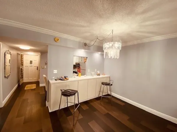 a view of a room with wooden floor and chandelier