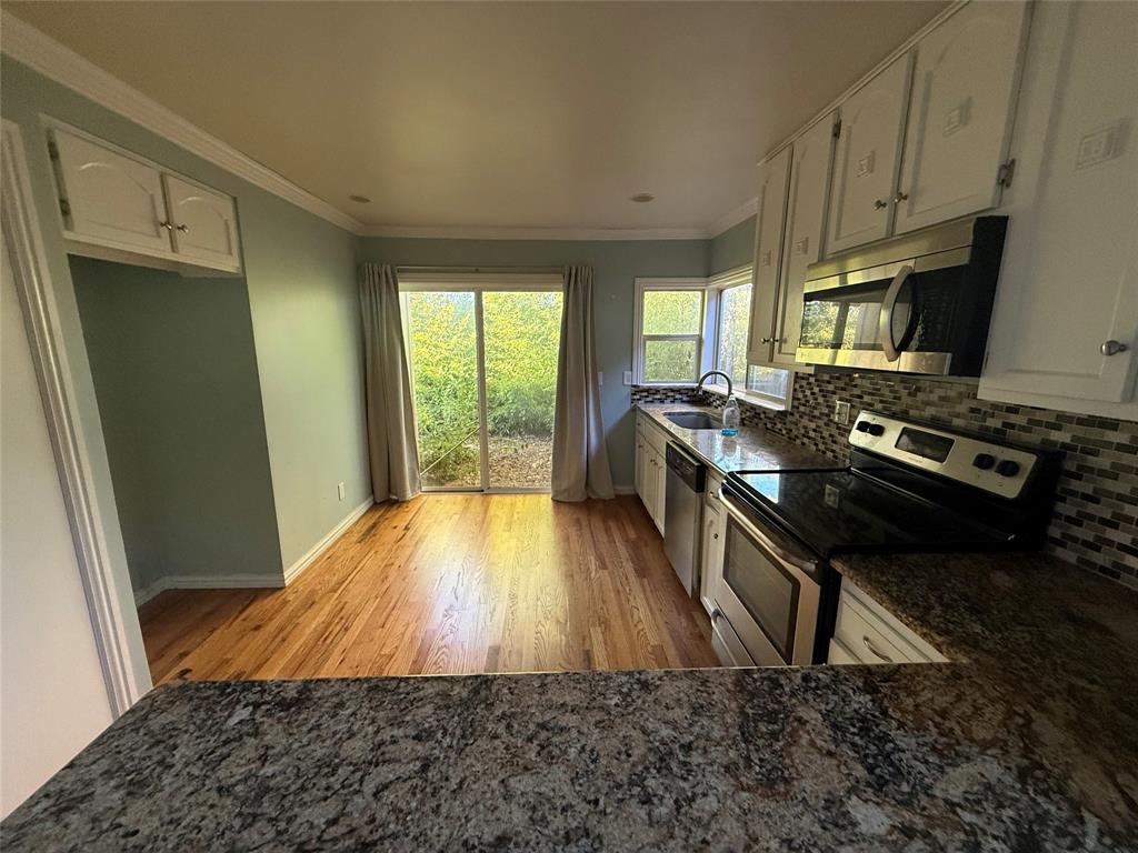 4139 Rosser Square Dallas, TX 75244 - Photo 4 of 7 a kitchen with wooden floors and a stove