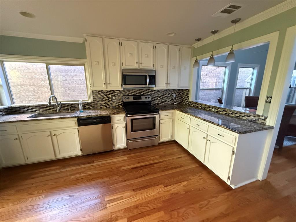 4139 Rosser Square Dallas, TX 75244 - Photo 6 of 7 a kitchen with stainless steel appliances granite countertop a stove a sink and a microwave