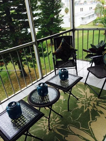 a view of a balcony with chairs and a potted plant
