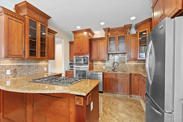 a kitchen with stainless steel appliances granite countertop a refrigerator and a sink
