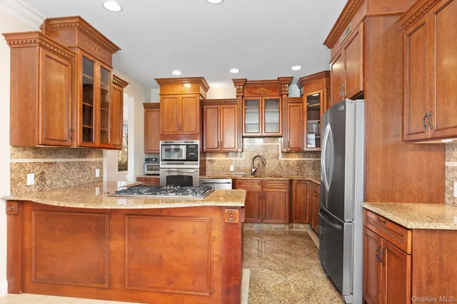 a kitchen with stainless steel appliances granite countertop a refrigerator and a sink