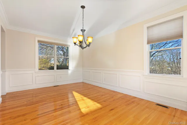a view of a room with wooden floor and a chandelier