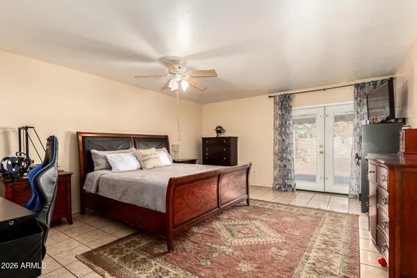 a bedroom with a bed a mirror and a chandelier