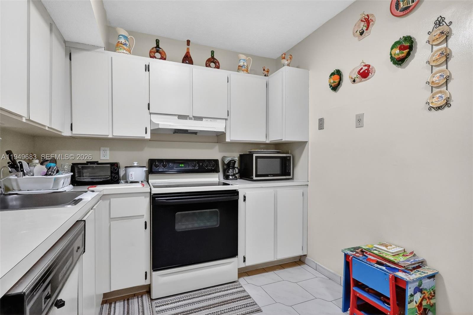 2224 West 53rd Place, Unit 2224 Hialeah, FL 33016 - Photo 13 of 27 a kitchen with a white cabinets and white appliances