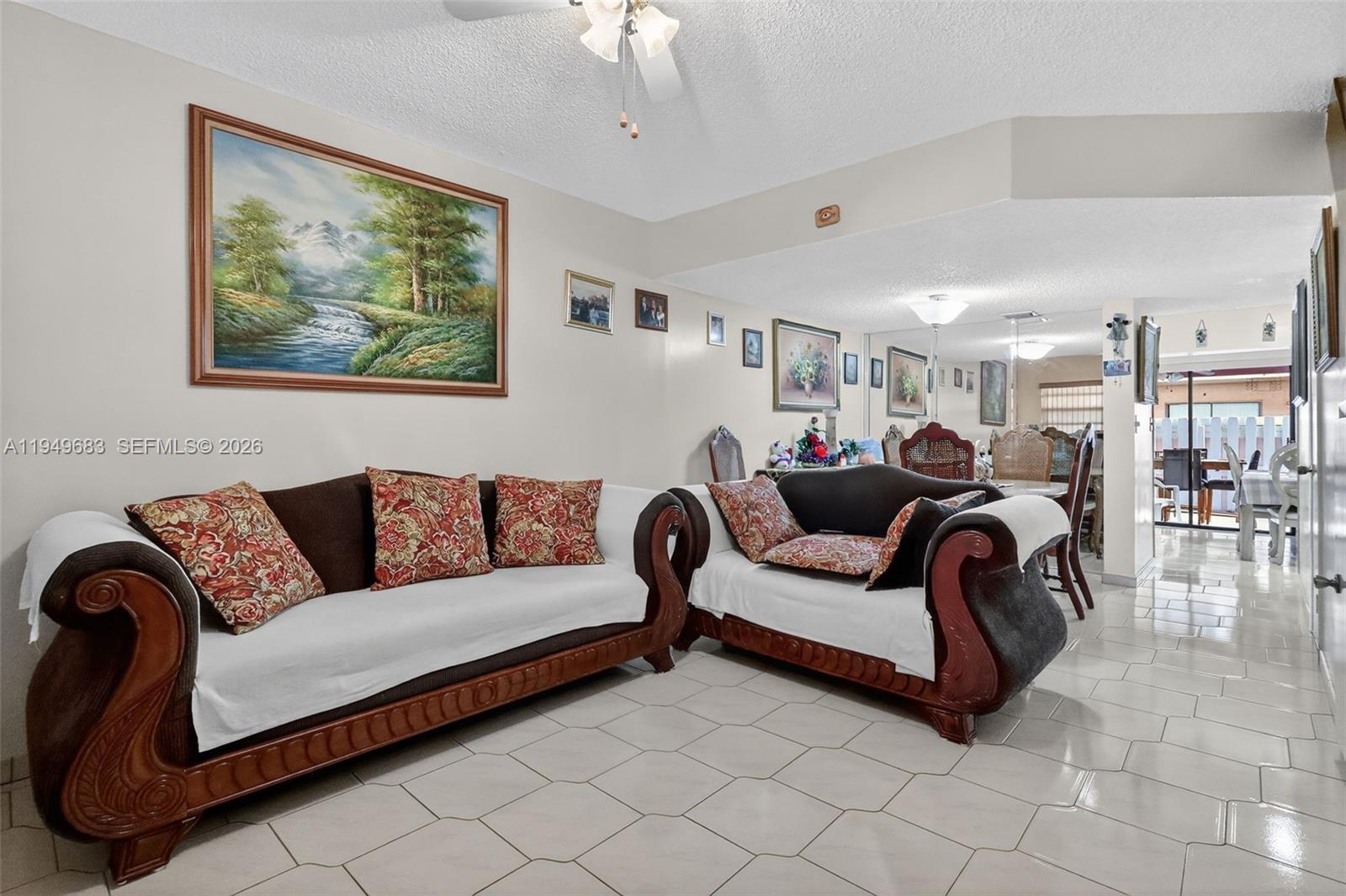 2224 West 53rd Place, Unit 2224 Hialeah, FL 33016 - Photo 5 of 27 a living room with furniture a couch and a chandelier