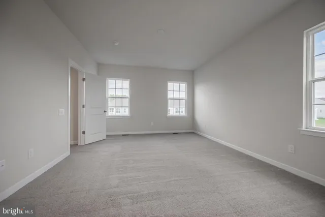 an empty room with fireplace and windows