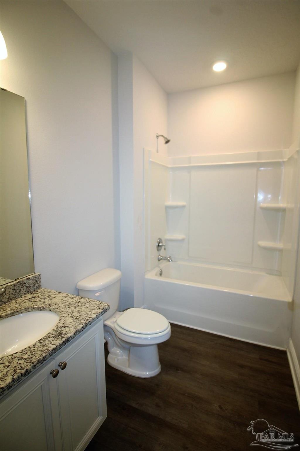 8006 Burnside Loop Pensacola, FL 32526 - Photo 18 of 22 a bathroom with a granite countertop sink a toilet a mirror and bathtub