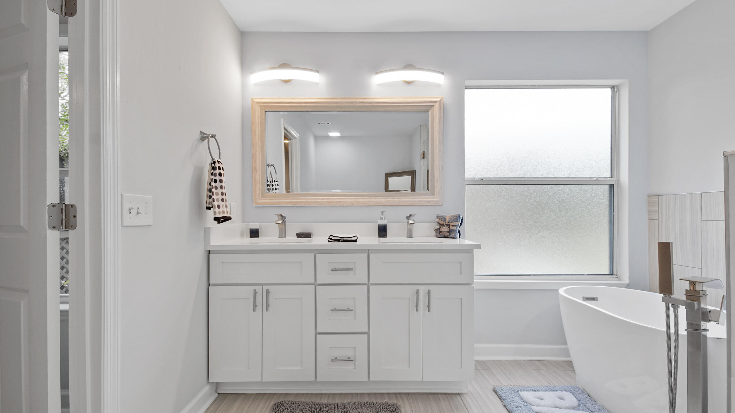 1190 Bay Court Destin, FL 32541 - Photo 29 of 52 a bathroom with a bathtub a mirror a sink and vanity
