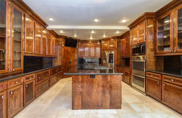 a kitchen with kitchen island a counter top space appliances and a window