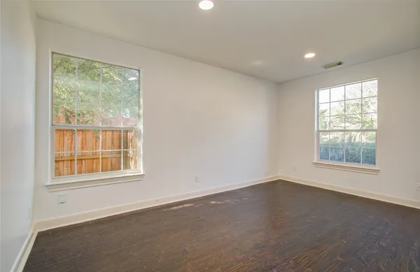 an empty room with wooden floor and a window