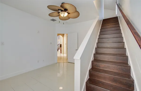 an empty room with a window and a fan