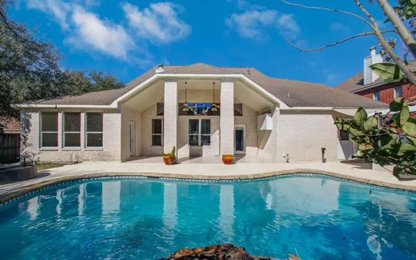 a view of a house with backyard porch and sitting area