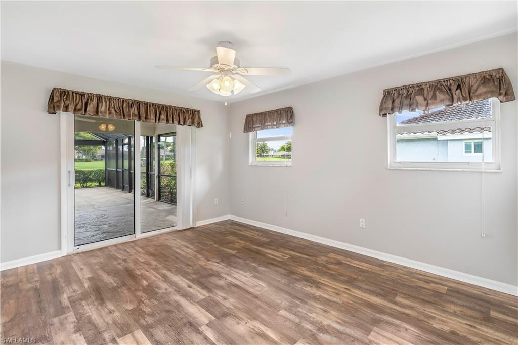 313 Forest Hills Boulevard Naples, FL 34113 - Photo 13 of 14 a view of an empty room with wooden floor and a window