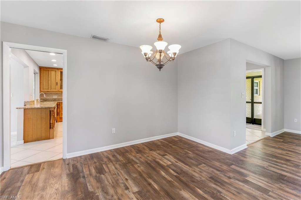313 Forest Hills Boulevard Naples, FL 34113 - Photo 14 of 14 a view of a room with wooden floor and a ceiling fan