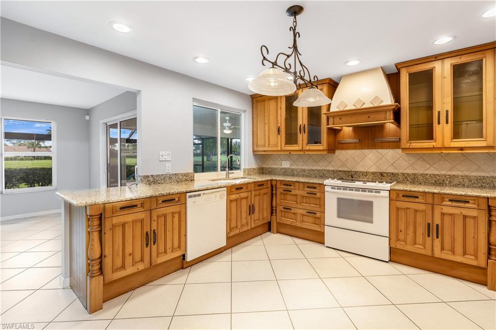 313 Forest Hills Boulevard Naples, FL 34113 - Photo 8 of 14 a kitchen with stainless steel appliances granite countertop a stove a sink and a microwave