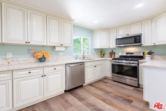 a kitchen with granite countertop white cabinets and white appliances