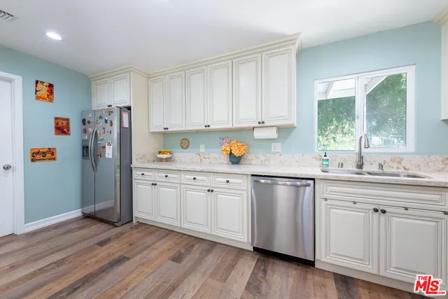 a kitchen with a refrigerator and white cabinets
