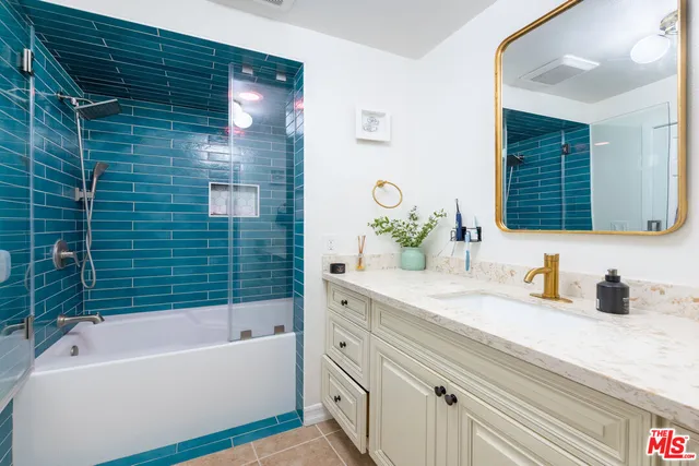 a bathroom with a tub a sink and mirror