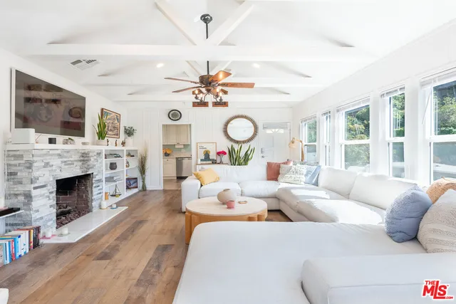 a living room with fireplace furniture and a large window