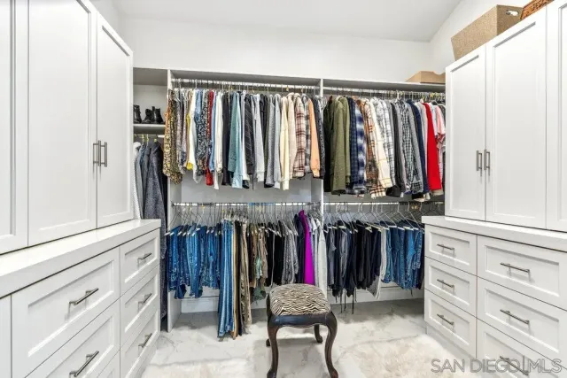 a view of walk in closet with clothes