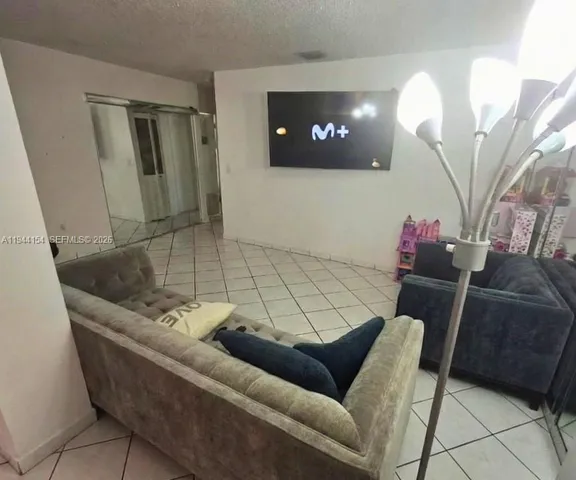 a living room with furniture and a mirror