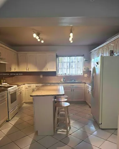 a kitchen with a cabinets and white stainless steel appliances