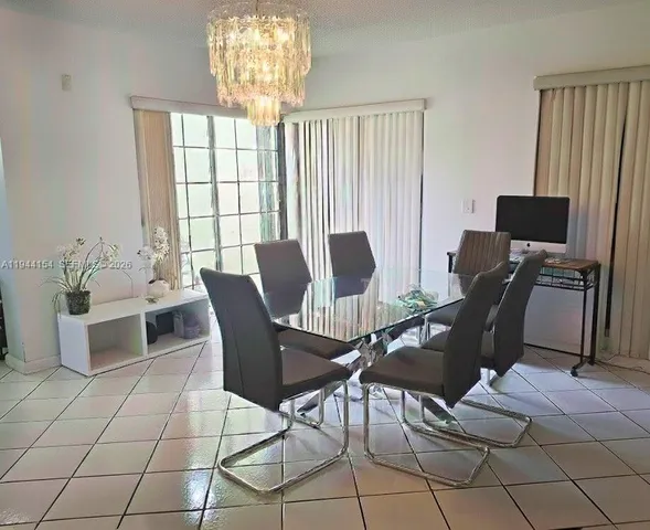a view of a dining room with furniture and chandelier