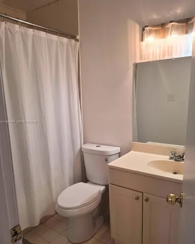 a bathroom with a sink a toilet and shower curtain