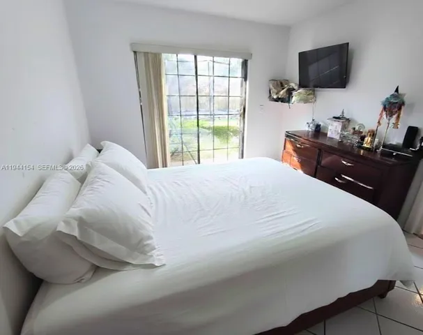 a bedroom with a bed and a flat tv screen on a dresser