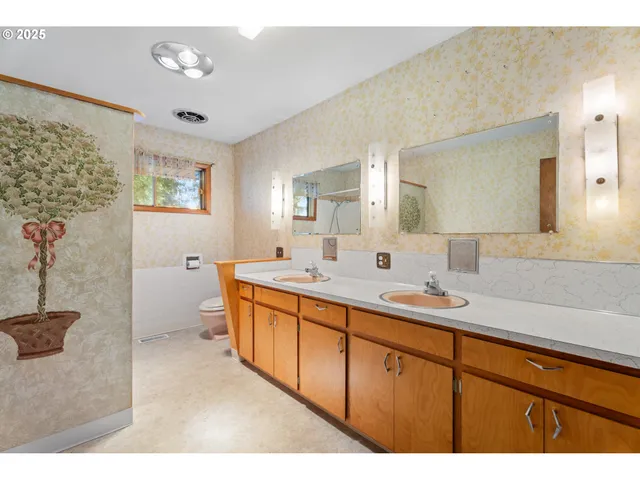 a spacious bathroom with a double vanity sink a mirror and a bathtub