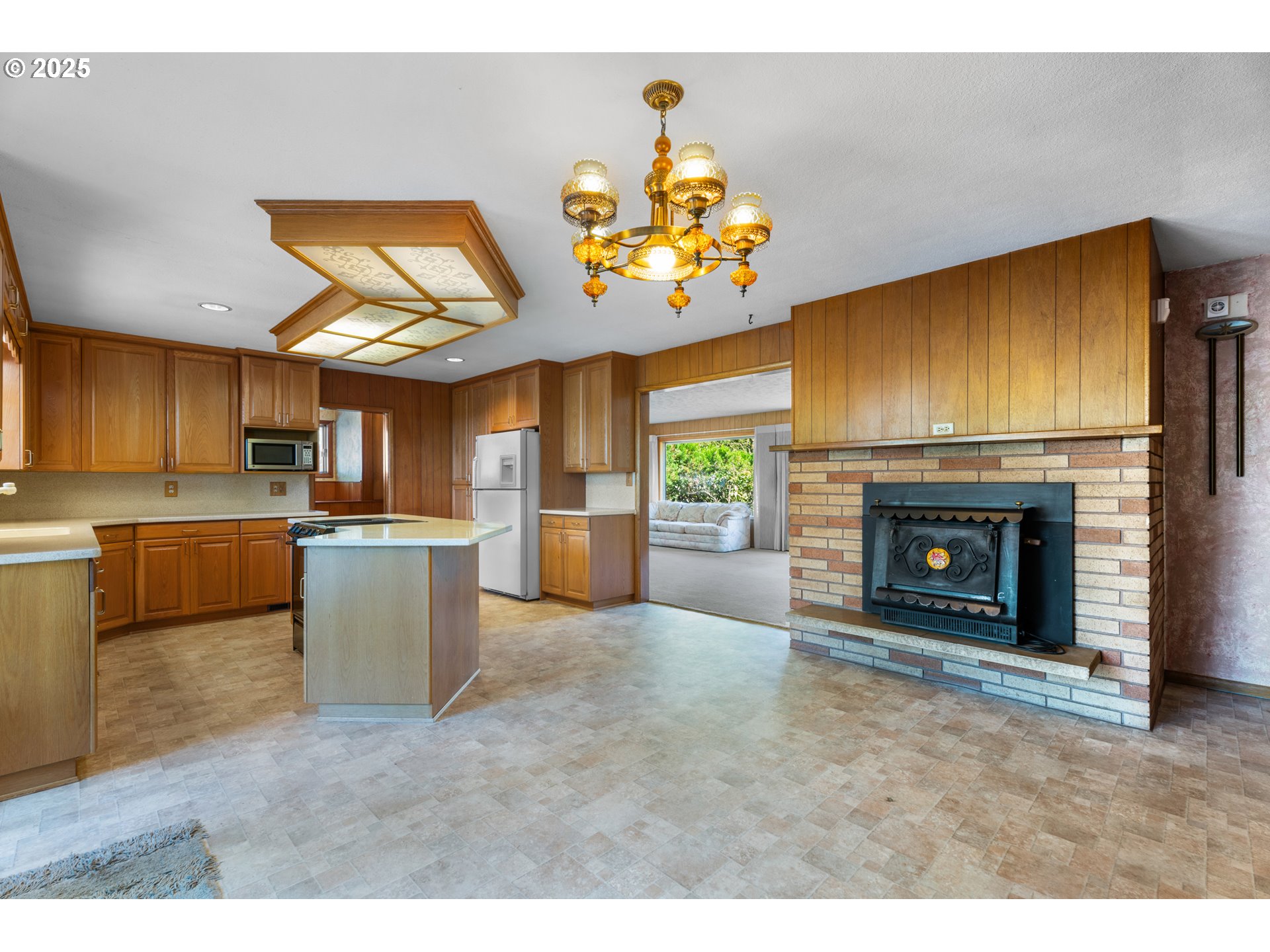 15895 Old Butteville Road Northeast Woodburn, OR 97071 - Photo 5 of 47 a view of a kitchen with a sink a kitchen a fireplace and a window