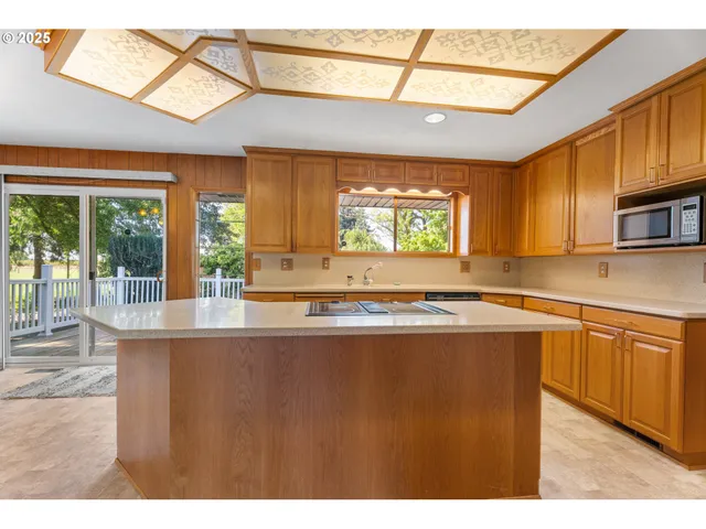 a kitchen with stainless steel appliances granite countertop a stove a sink and a microwave