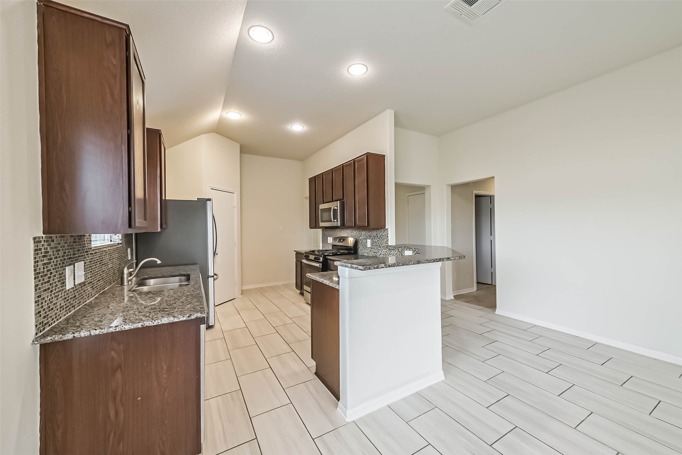 2630 Zephyr Lane Rosenberg, TX 77471 - Photo 11 of 33 a kitchen with a sink refrigerator and microwave