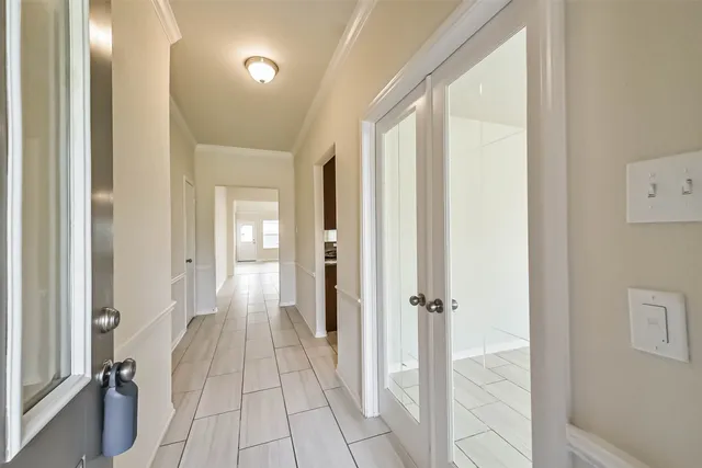 a view of a hallway with a livingroom and a bathroom with sink