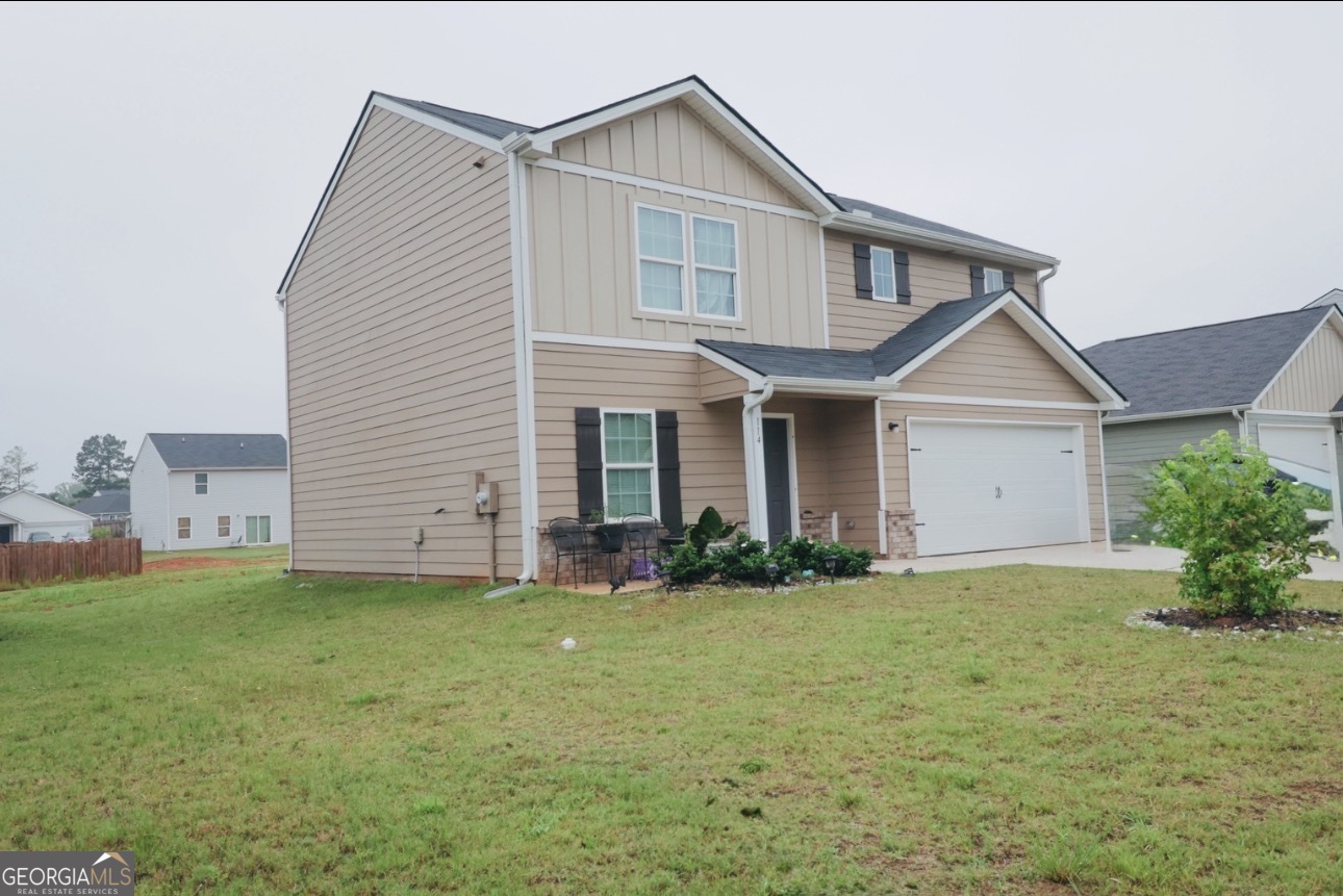 114 Catalpa Road Milner, GA 30257 - Photo 2 of 2 a front view of a house with a yard and garage