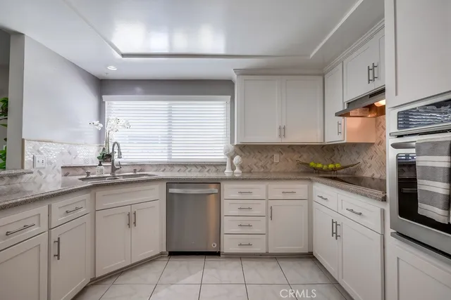 a kitchen with cabinets appliances a sink and a window