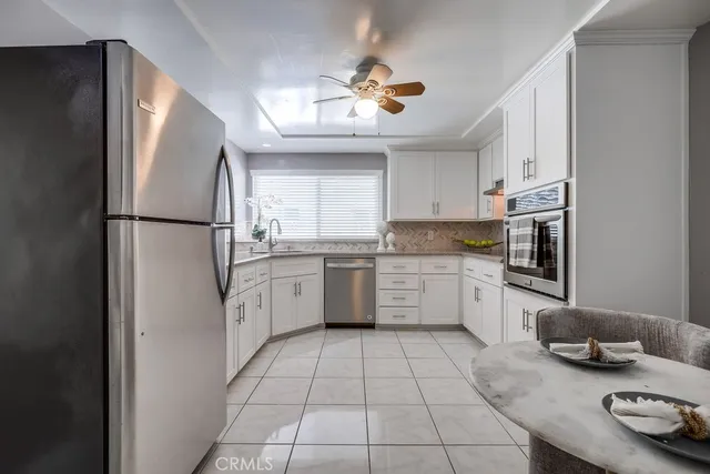 a kitchen with stainless steel appliances granite countertop a refrigerator sink and stove