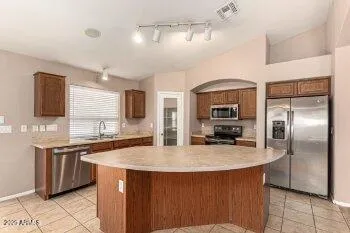 a kitchen with stainless steel appliances a sink stove and refrigerator
