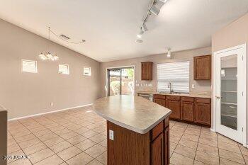 10344 West Trumbull Road Tolleson, AZ 85353 - Photo 8 of 22 a kitchen with a sink a refrigerator and wooden cabinets
