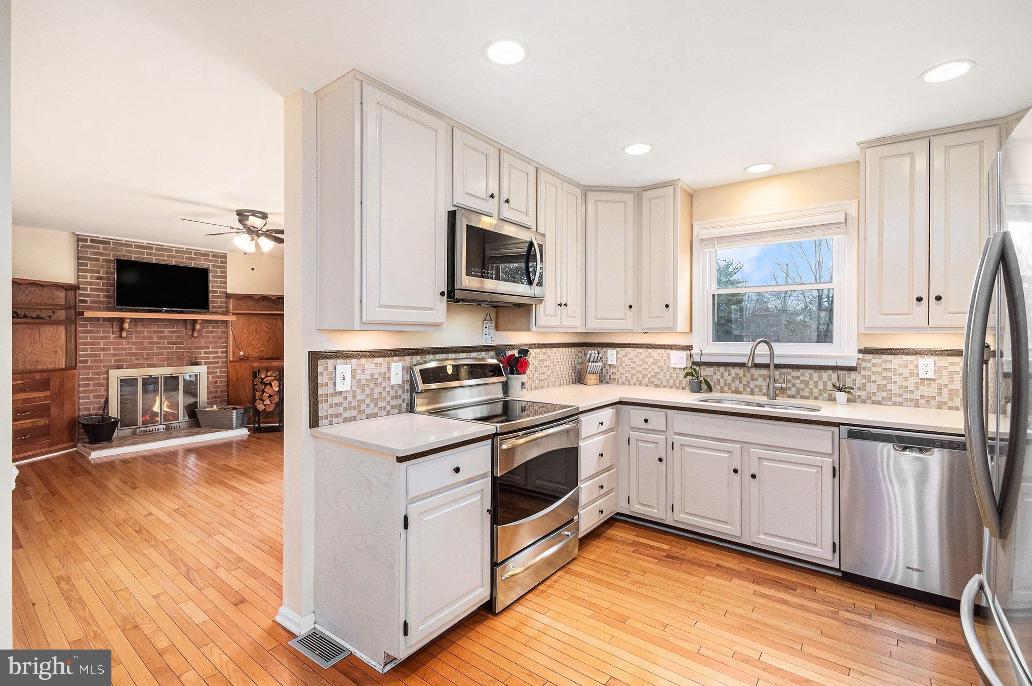 1309 Rock Chapel Road Herndon, VA 20170 - Photo 11 of 41 a kitchen with stainless steel appliances granite countertop a stove top oven a sink dishwasher and a microwave oven with wooden floor