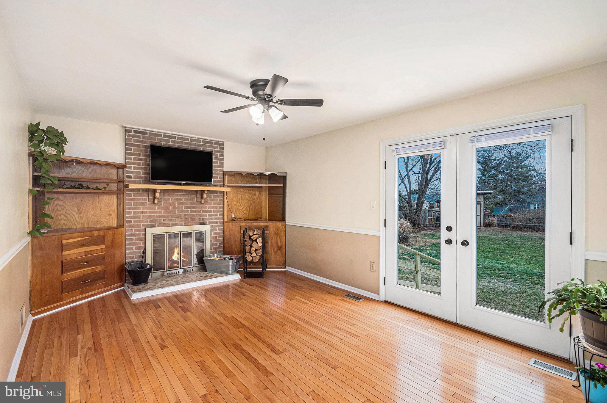 1309 Rock Chapel Road Herndon, VA 20170 - Photo 15 of 41 a view of a livingroom with a flat screen tv a fireplace and wooden floor