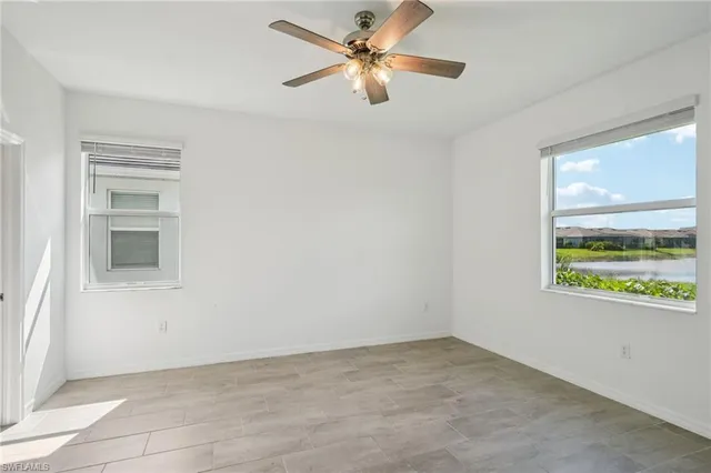 an empty room with a window and a ceiling fan