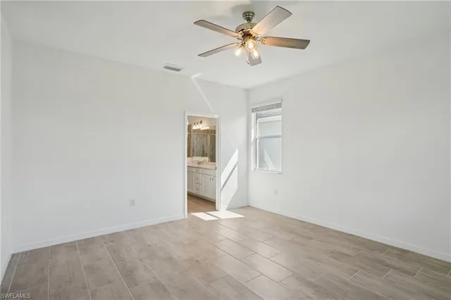 an empty room with a ceiling fan and a window